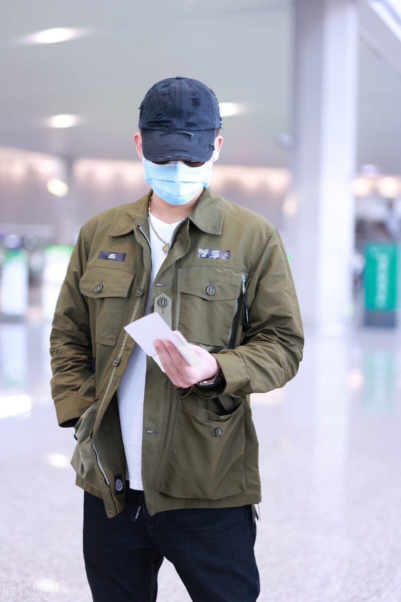 欧豪身穿军绿色外套仿佛特种兵,独自拎大包小裹赶行程