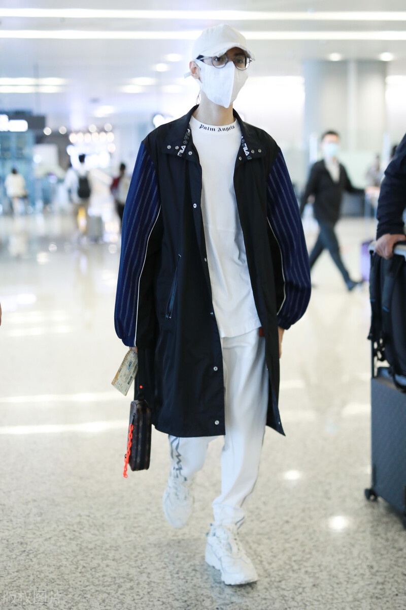 罗云熙现身机场,穿白色打底衫外搭拼接风衣,头戴白色帽子很帅气