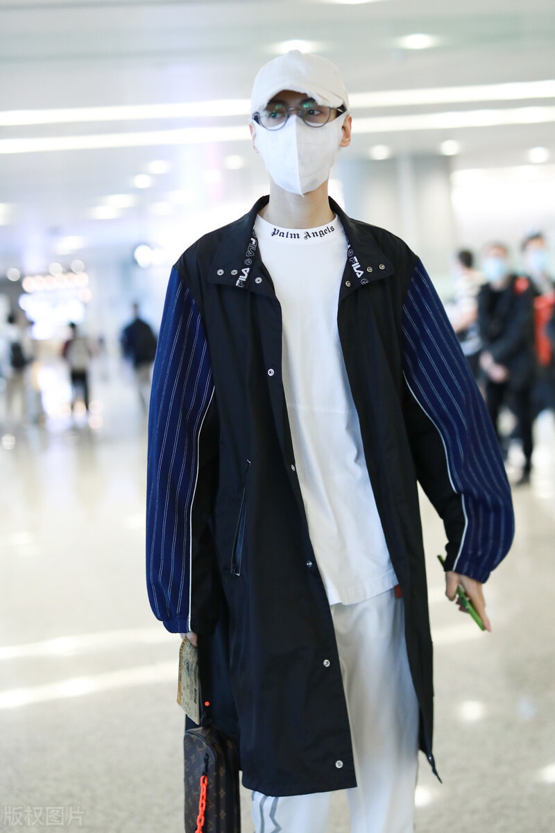 罗云熙现身机场,穿白色打底衫外搭拼接风衣,头戴白色帽子很帅气