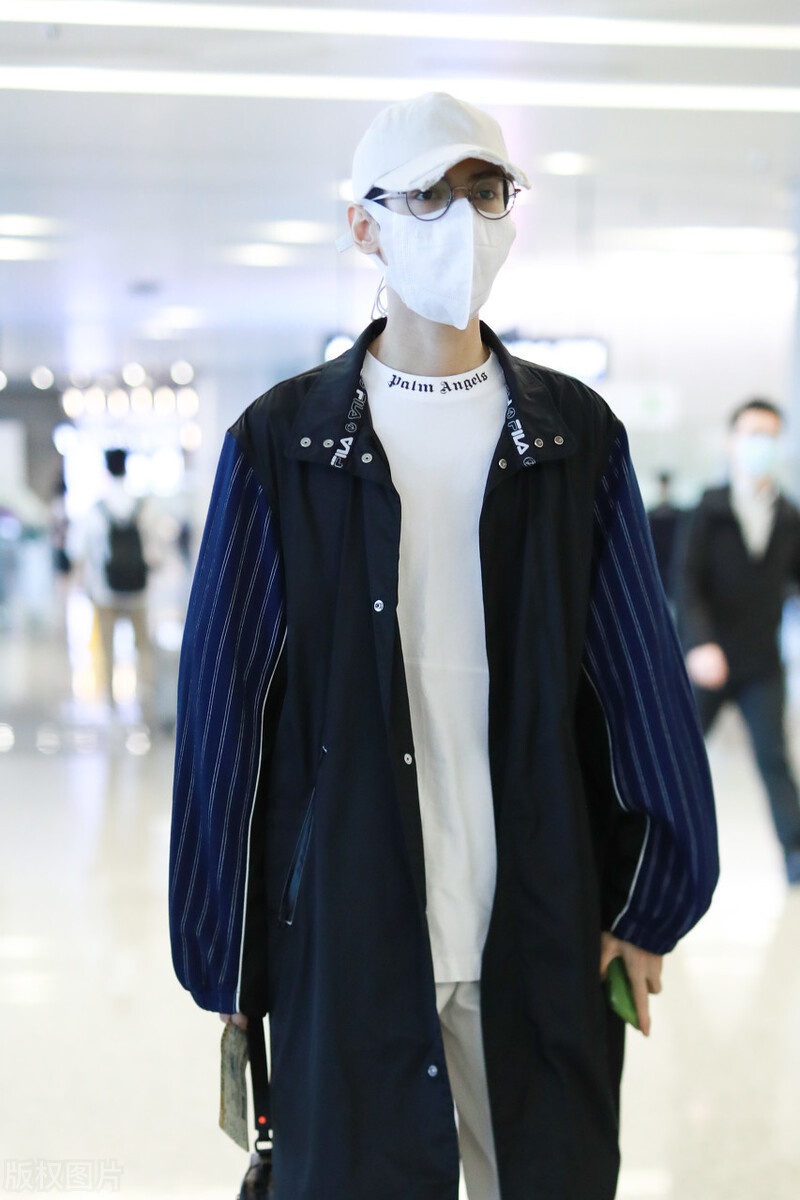 罗云熙现身机场,穿白色打底衫外搭拼接风衣,头戴白色帽子很帅气