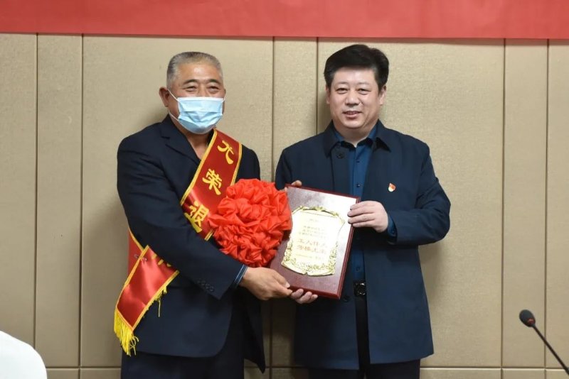 会议最后,连伟亮亲手将"光荣退休"的荣誉牌赠送给杨新能,集团领导共同