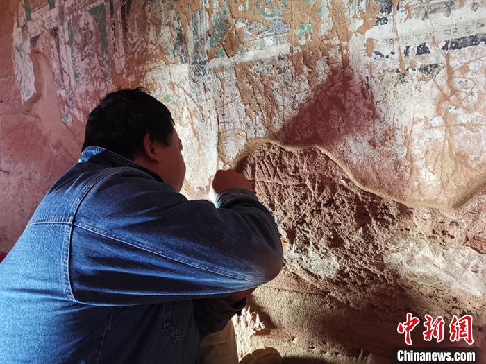 图为专家在修复阿尔寨石窟壁画。　内蒙古阿尔寨石窟供图 