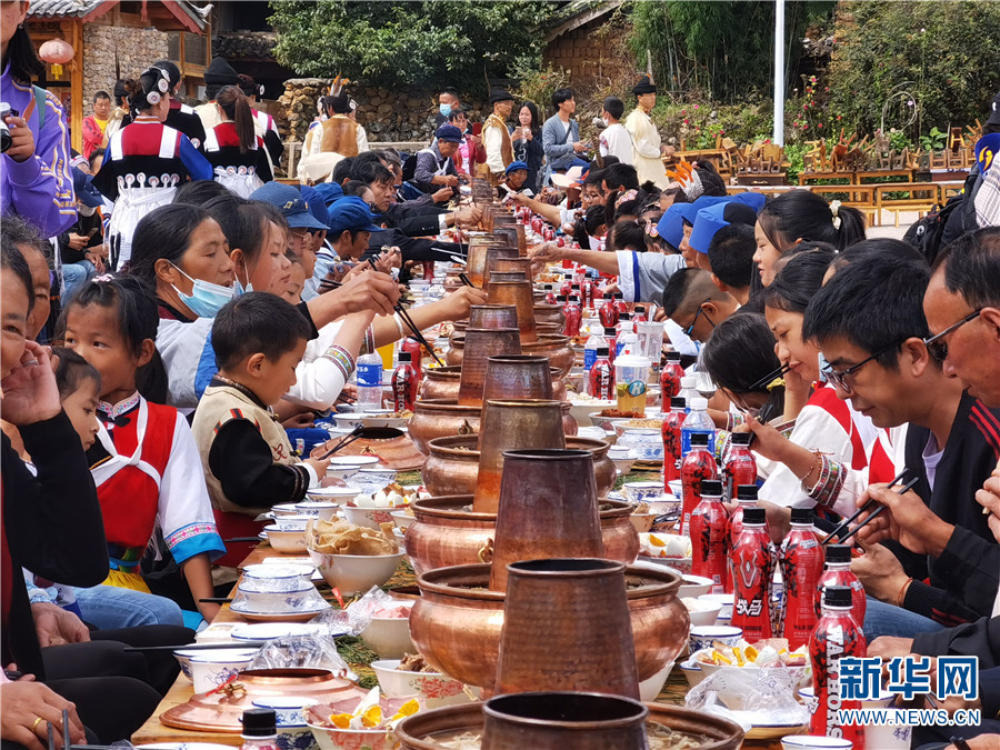 游客与村民同吃长街宴,感受民族文化魅力(10月6日摄).