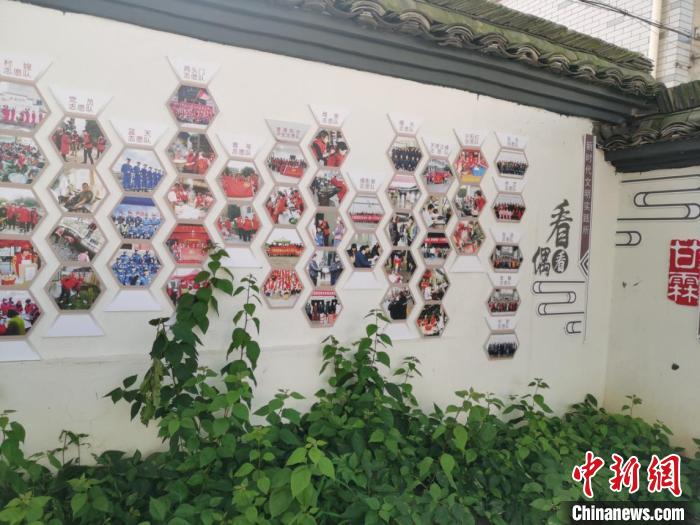 美丽城镇中"红马甲"志愿者照片墙.嵊州市宣供图