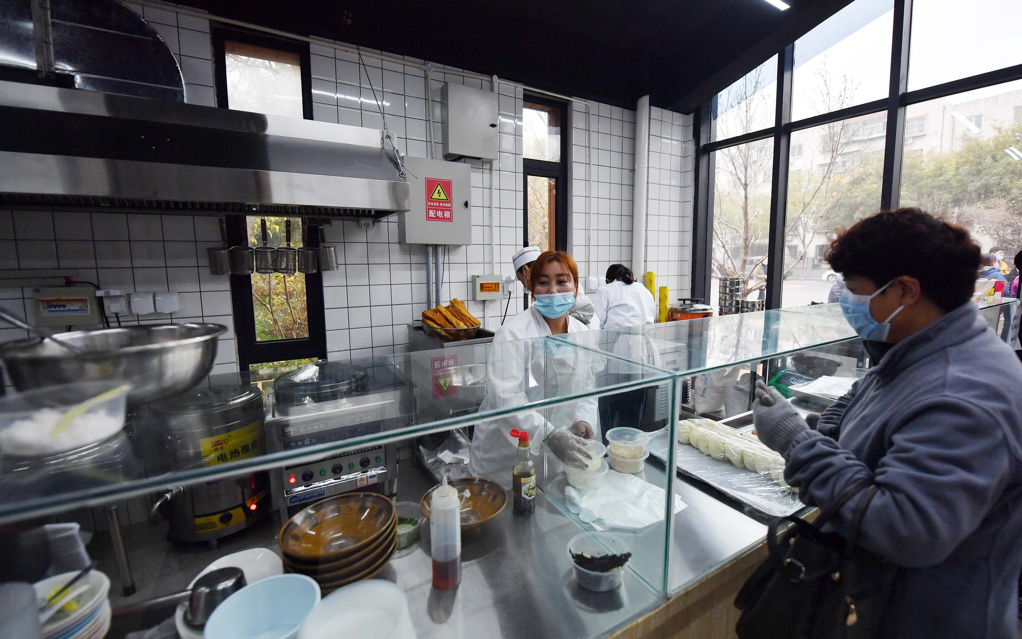 居民在大兴区枣园社区内的主食厨房购买早点.摄影/新京报记者 李木易