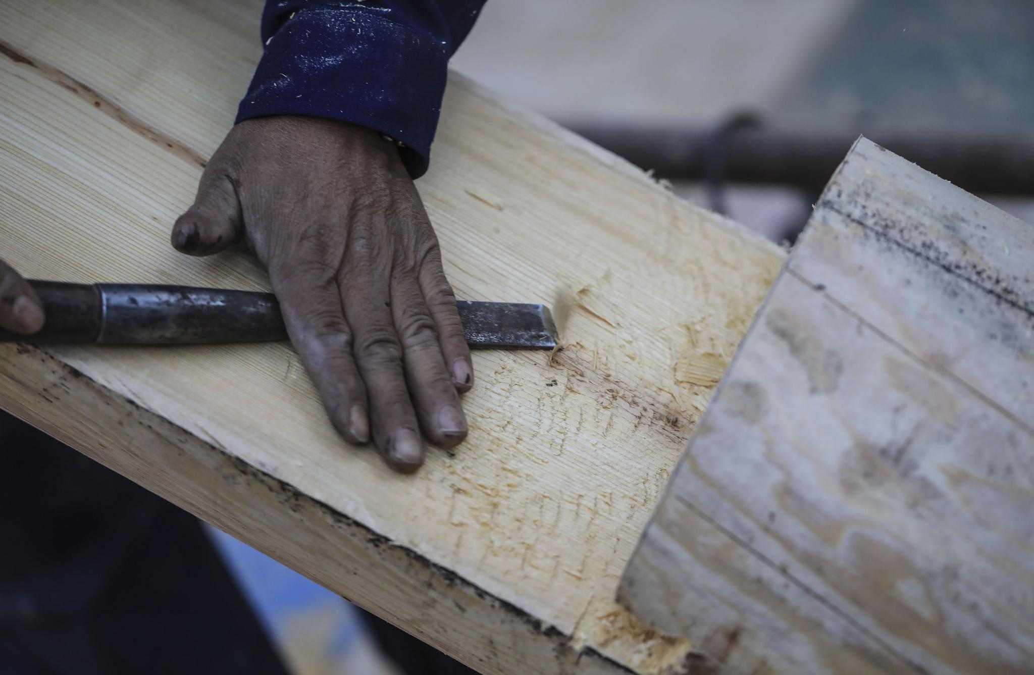 工人师傅在为墩接的新料修整平面,很多操作仍然使用传统木工工具.