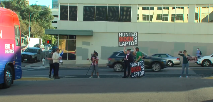 标语牌上书“亨特·拜登的电脑”，指前段时间《纽约邮报》爆出的拜登父子“丑闻”（视频截图）