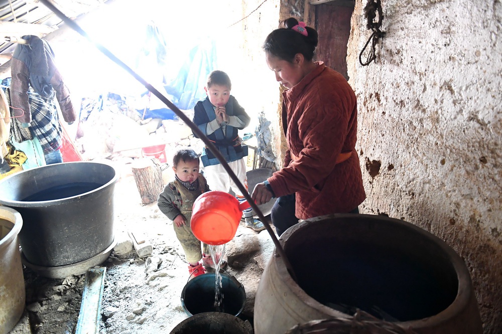在广西南丹县里湖瑶族乡,一个村民从水缸里舀水(2018年2月5日摄).