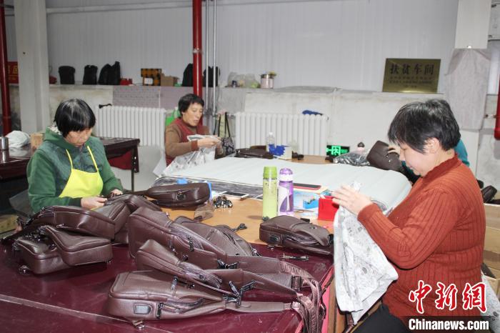 阜平顾家台村九歌皮具有限公司的“扶贫车间”，女工们正在为背包装配拉链。　徐巧明 摄
