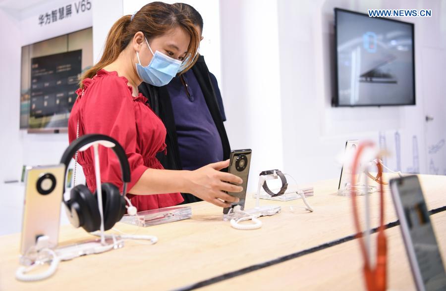 Visitors try a 5G smartphone at a 5G-themed exhibition held during the World 5G Convention in Guangzhou, south China's Guangdong Province, Nov. 26, 2020. The 2020 World 5G Convention kicked off in Guangzhou Thursday, during which world-renowned infocom scientists, 5G service providers and 5G application adopters will exchange ideas on aspects of cutting-edge technologies, industrial development trends and innovative applications in 5G industry. (Xinhua/Deng Hua)