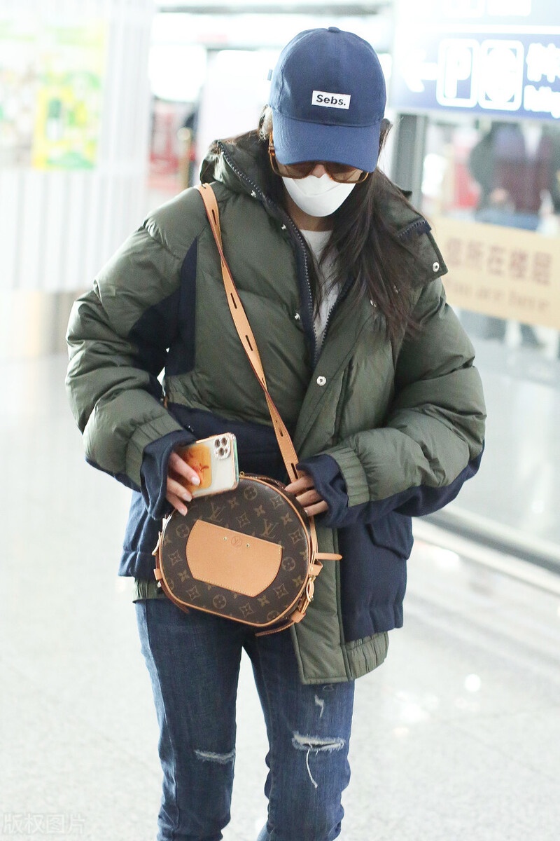黄圣依穿墨绿色羽绒服现身机场戴墨镜鸭舌帽明星标配