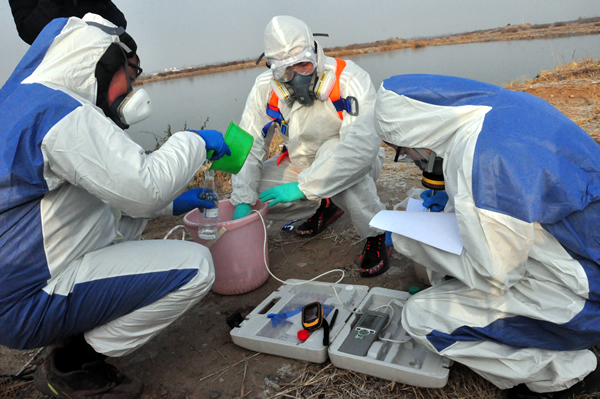 环境监测人员开展水质采样工作