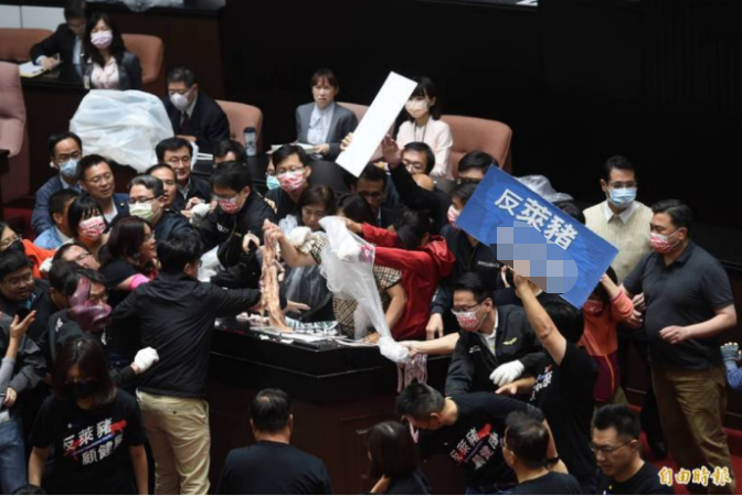 苏贞昌上发言台，国民党团拿猪内脏、猪皮泼在发言台上。图自“自由时报”