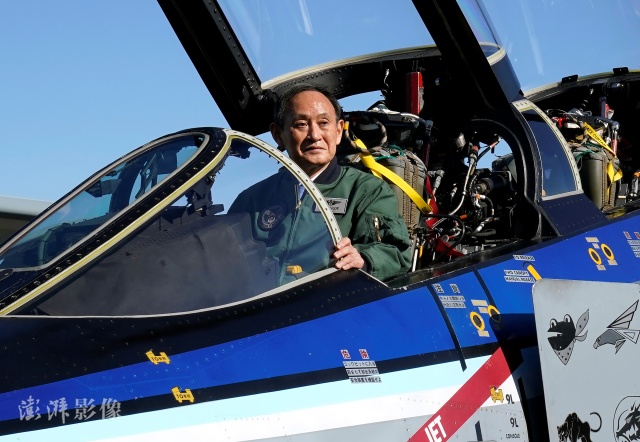 菅义伟坐在即将退役的F-4战机驾驶舱内，拍照留念。