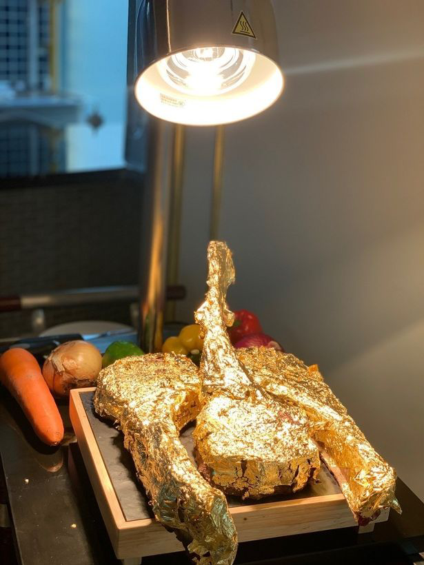 比如餐厅里设计的菜肴里,有"24k黄金"包裹的战斧牛排,还有可食用的"金