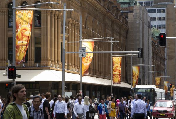 资料图：在澳大利亚悉尼市中心，行人从中国农历蛇年的招贴画下走过。（新华社）