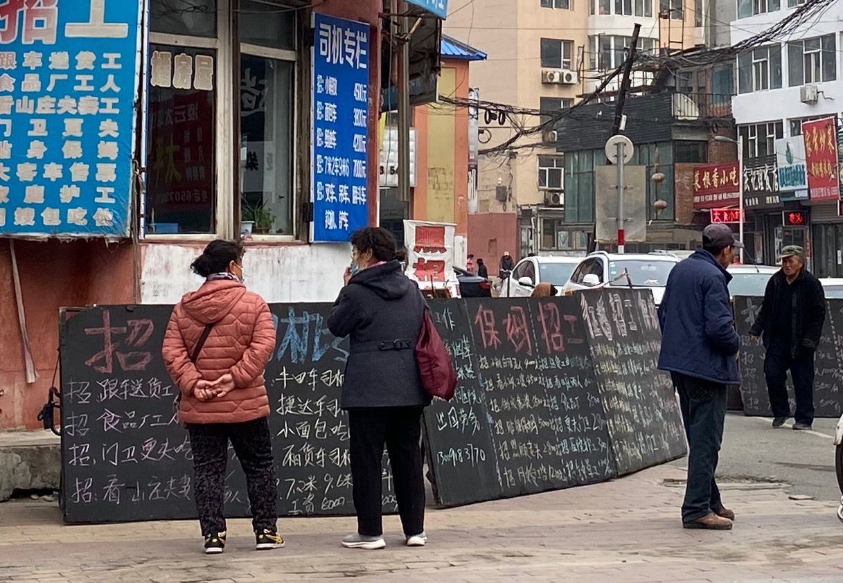 吉林市劳动力市场旧址，招工小黑板前站着等工的女人。现在家政服务成为这些女工工作的主流。新京报记者 肖薇薇 摄