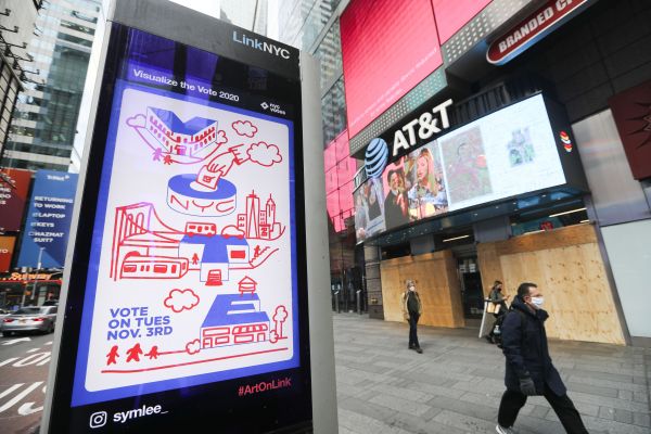  11月2日，行人经过美国纽约时报广场上鼓励投票的广告。新华社