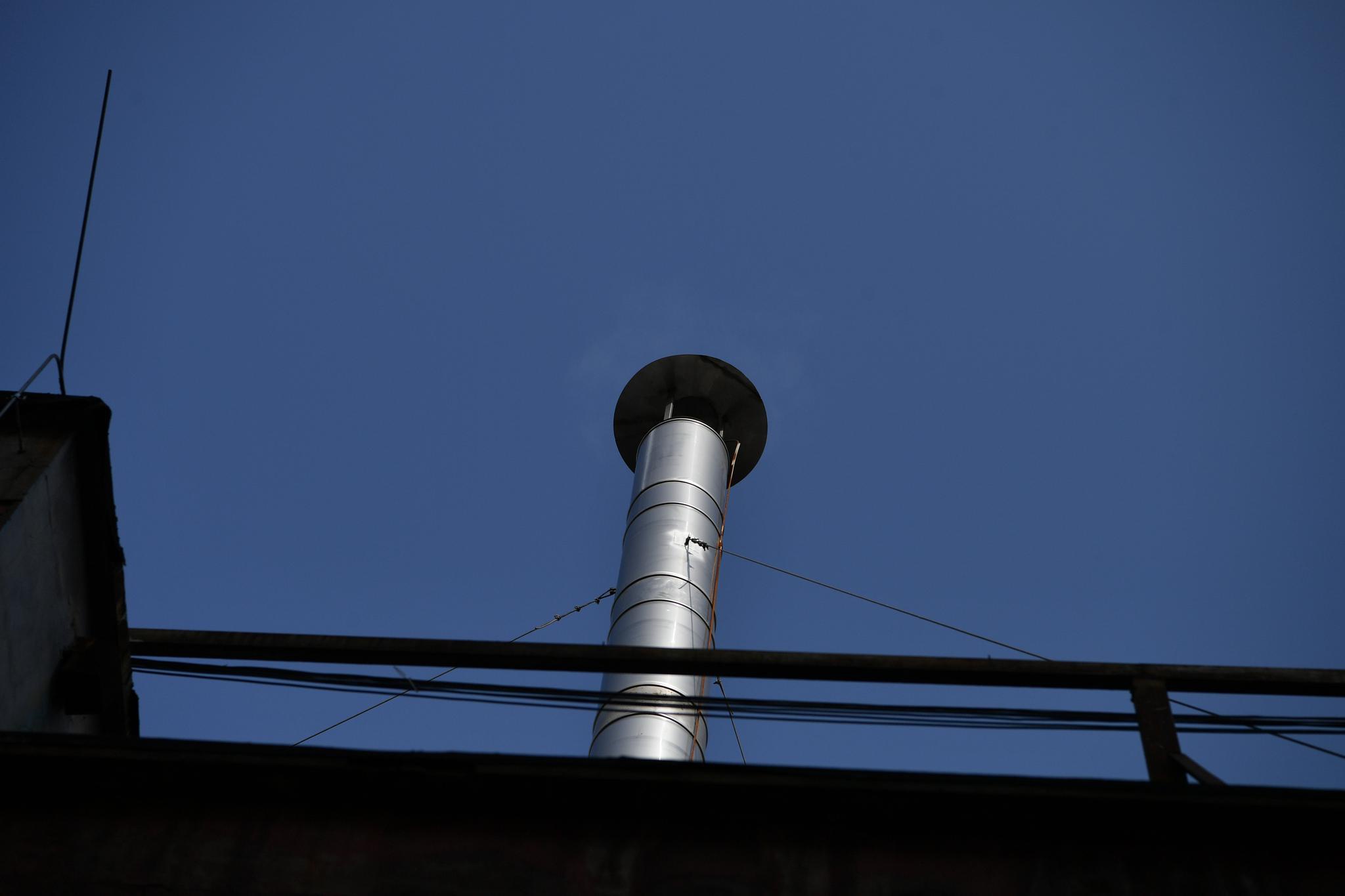 六里桥锅炉房启动锅炉后,屋顶烟囱冒出淡淡烟气.摄影/新京报记者 吴江