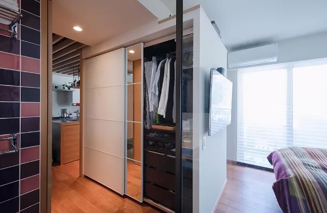 卧室还设计的衣帽间,利用走道中间位置,将两组衣柜背靠背叠放,其中一