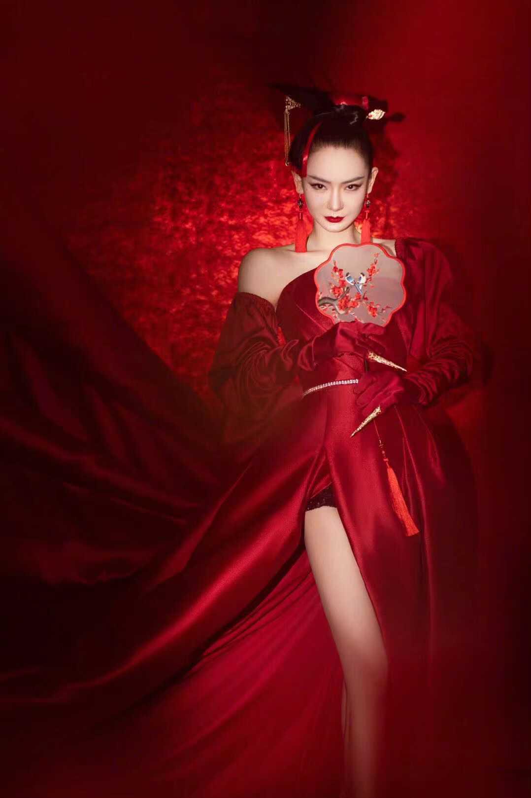 戚哥身穿拖地红色长裙手持刺绣圆扇