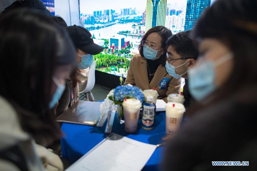 Job seekers communicate with staff from an enterprise at a job fair in the Hongshan Gymnasium in Wuhan, central China's Hubei Province, Dec. 2, 2020. A national colleage graduates employment and entrepreneurship promotion fair kicked off here on Wednesday. Over 500,000 jobs vacancies were offered to applicants. (Xinhua/Xiao Yijiu)