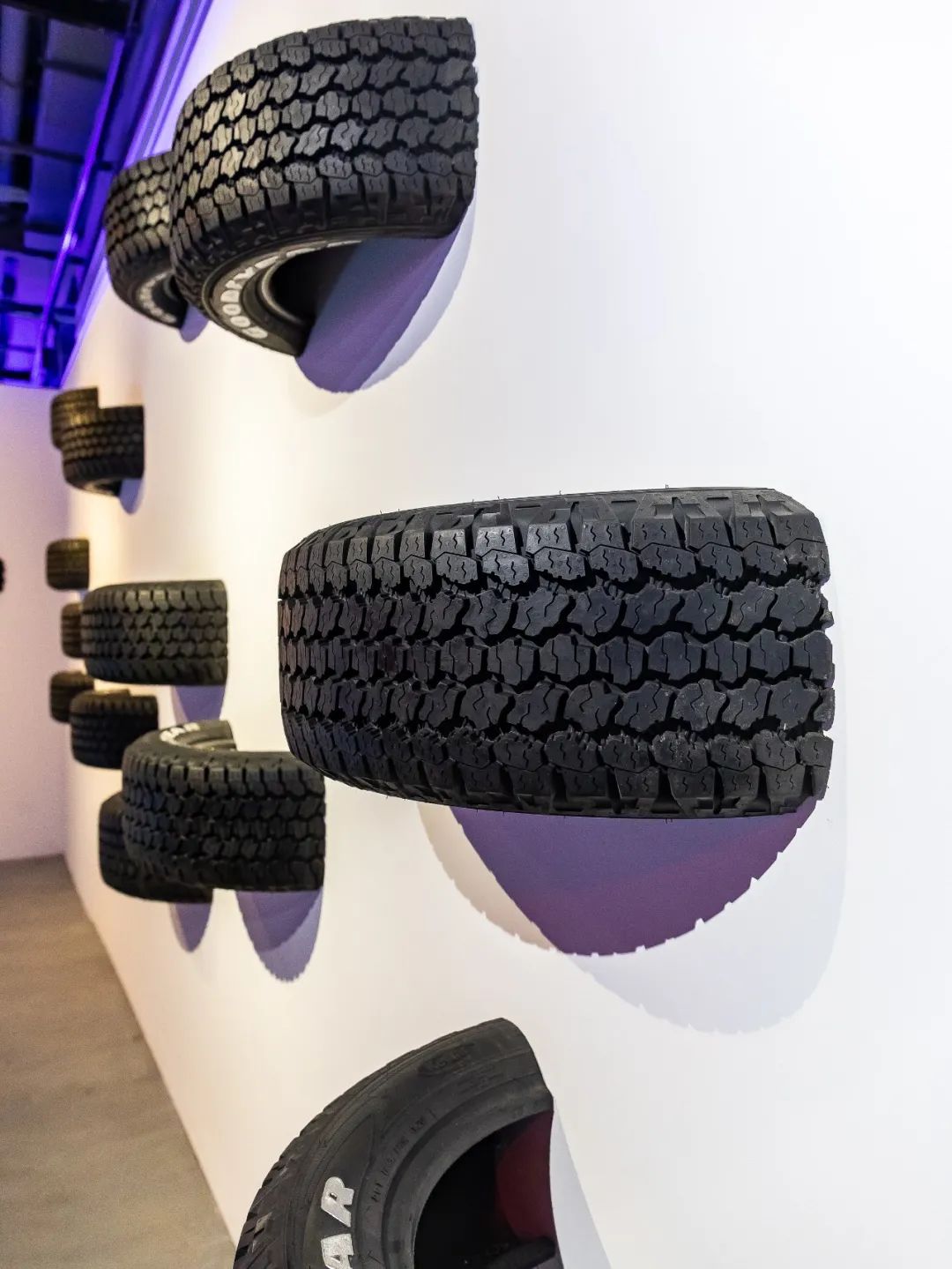 每个轮胎都见证了过往的历史 整面墙都被不同花纹的轮胎挤满 代表着