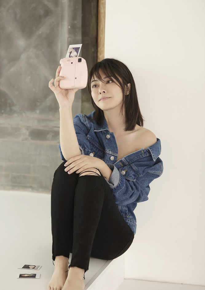 朱锐身穿深蓝色牛仔衣,把衣服弄成斜肩,有一种别致的性感,黑色小脚裤