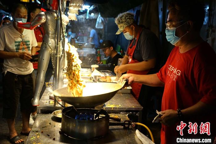 图为店家花式炒菜. 中新社记者 陈悦 摄