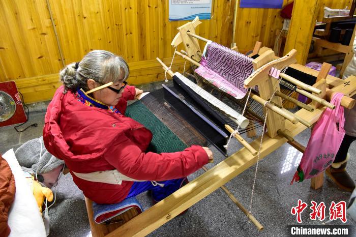 土家族织锦沿用汉代腰机式斜织机,以红,蓝,白棉线为经线,以各色丝线