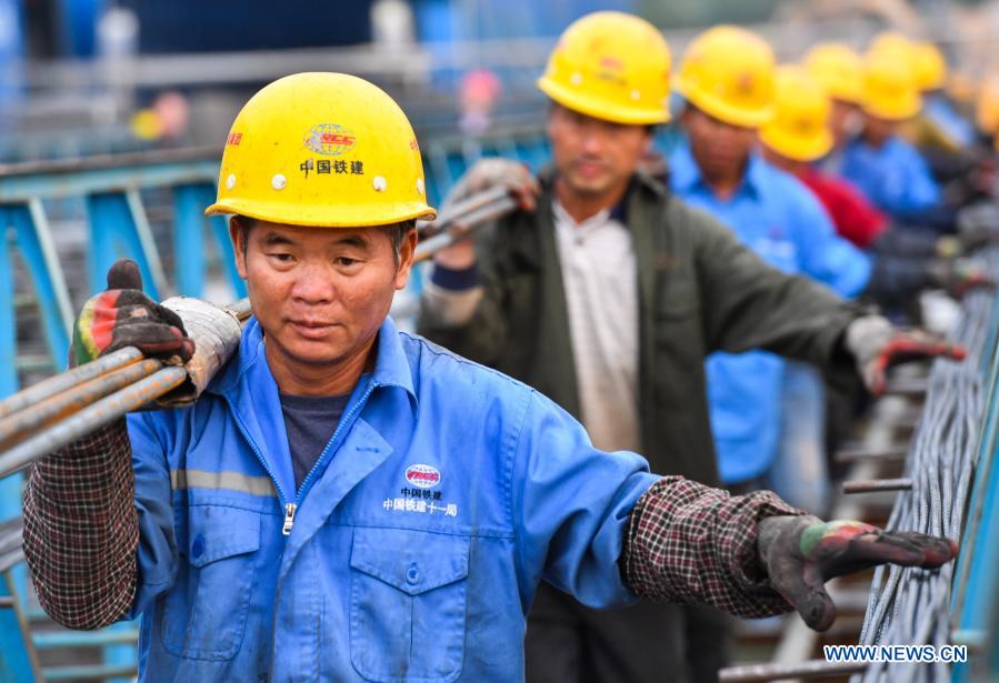 Workers carry steel bars used in the construction of Hezhou-Gaolan Port Highway in south China's Guangdong Province, Dec. 9, 2020. Upon completion, the 35-km highway will be an important channel linking the west bank of the Pearl River estuary and the Guangdong-Hong Kong-Macao Greater Bay Area. (Xinhua/Liu Dawei)