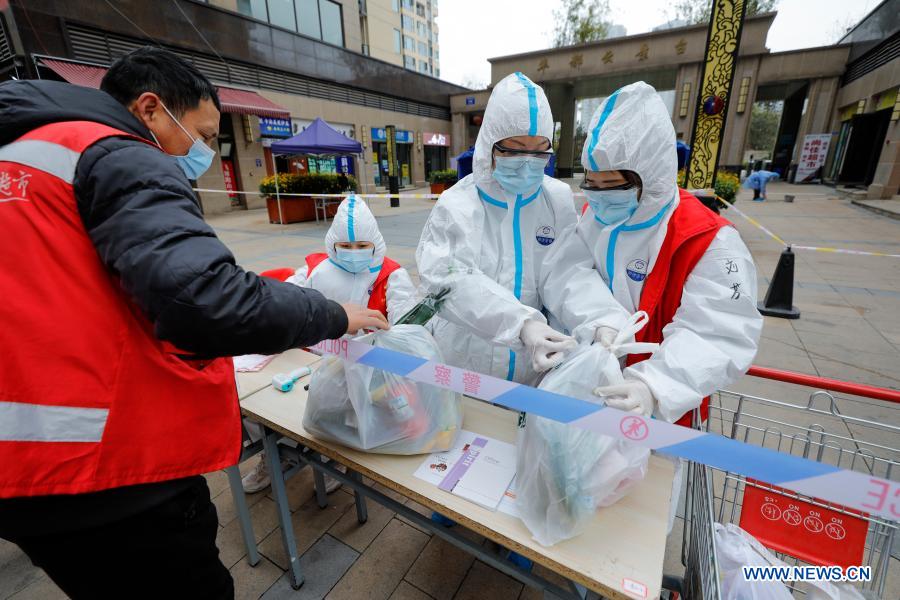 Staff members and volunteers mark daily necessities ordered by residents before delivering them to households at a quarantined residential community in Chenghua District of Chengdu, southwest China's Sichuan Province, Dec. 10, 2020. The community has been re-classified as a COVID-19 medium-risk area starting from 9:00 p.m. on Dec. 8. Its 300-plus households have all been kept in home quarantine. About 70 community workers and volunteers have been assigned to deliver the residents' daily necessities. (Xinhua/Shen Bohan)