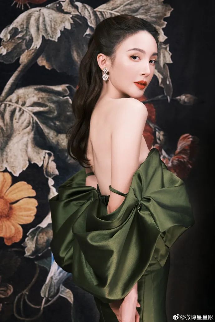 金晨穿着墨绿色长裙,大胆露出自己光滑白皙的后背,同时侧面小露缀己