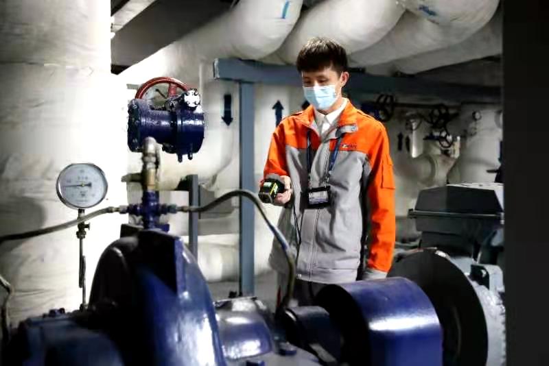 暖通空调系统运行员正在换热机房巡视检查。摄影/通讯员 刘文倩
