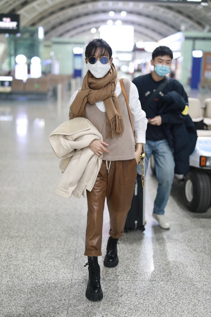 张静初穿白衬衫配马甲现身机场,面戴墨镜精致打扮一番