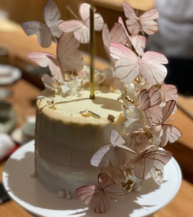 侯佩岑对着蝴蝶风格的生日蛋糕,双手合十许愿,吹蜡烛,看起来开心极了.