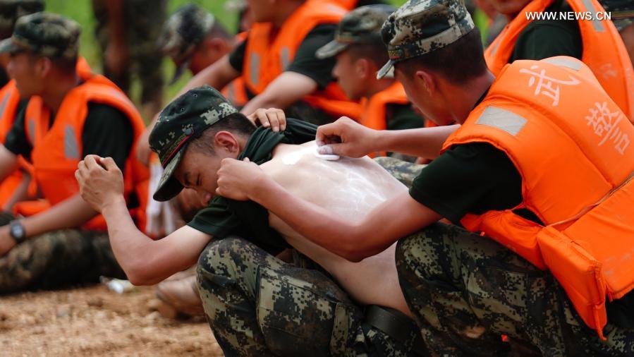 Rescuer applies powders on the sunburnt back of his colleague during the break of flood containment mission at Jiangjialing Village in Poyang County, east China's Jiangxi Province, July 11, 2020. Looking back at 2020, there are always some warm pictures and touching moments: the dedication on the front line to fight against the epidemic, the perseverance on the way out of poverty, the courage to shoulder the responsibility on the embankment against the flood, the joy and pride when reaching the summit of Mount Qomolangma... These people and things touch our hearts and give us warmth and strength. (Xinhua/Zhou Mi)
