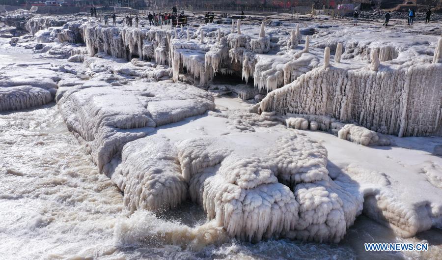 Aerial photo taken on Dec. 16, 2020 shows visitors enjoying the winter scenery at the Hukou Waterfall scenic spot in northwest China's Shaanxi Province. The Hukou waterfall, located on the border area between north China's Shanxi and northwest China's Shaanxi provinces, formed spectacular winter scenery as temperature continued to drop in recent days. (Xinhua/Tao Ming)
