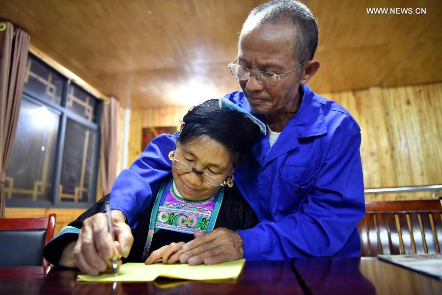 Villager Liang Anhe (R), 70, teaches his wife Liang Yingmi, 67, to write Chinese characters during a Mandarin training program in Wuying Village, a remote village inhabited by the Miao ethnic group where women over 40 have hardly ever attended any school, on the border between south China's Guangxi Zhuang Autonomous Region and southwest China's Guizhou Province, on Sept. 14, 2020. Looking back at 2020, there are always some warm pictures and touching moments: the dedication on the front line to fight against the epidemic, the perseverance on the way out of poverty, the courage to shoulder the responsibility on the embankment against the flood, the joy and pride when reaching the summit of Mount Qomolangma... These people and things touch our hearts and give us warmth and strength. (Xinhua/Li Xin)