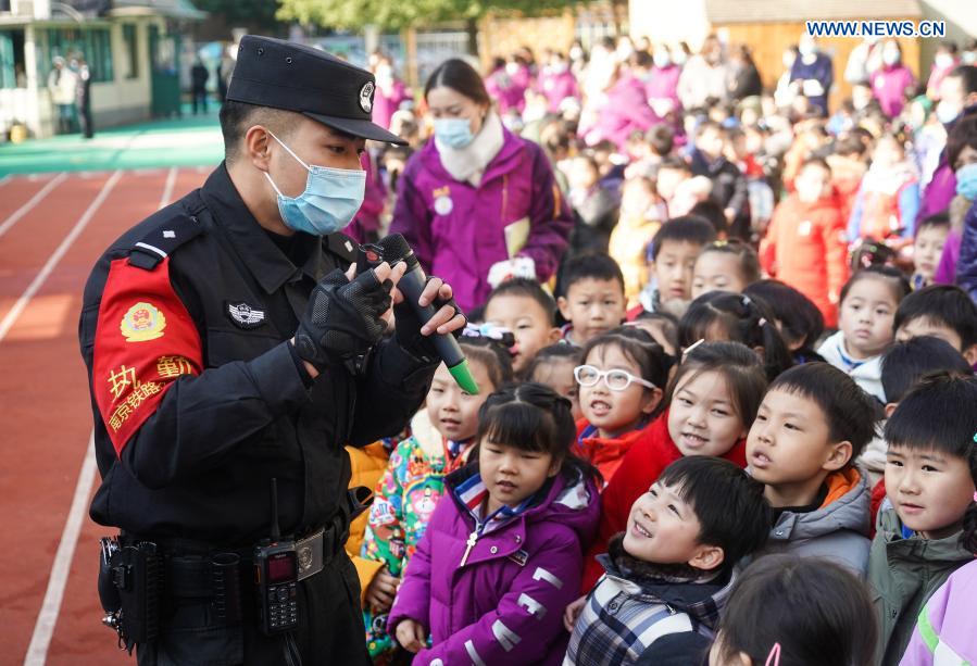 A policeman introduces a police gadget to children at a kindergarten during an activity to help enhance children's traffic safety and self-protection awareness in Nanjing, east China's Jiangsu Province, Dec. 16, 2020. (Xinhua/Ji Chunpeng)