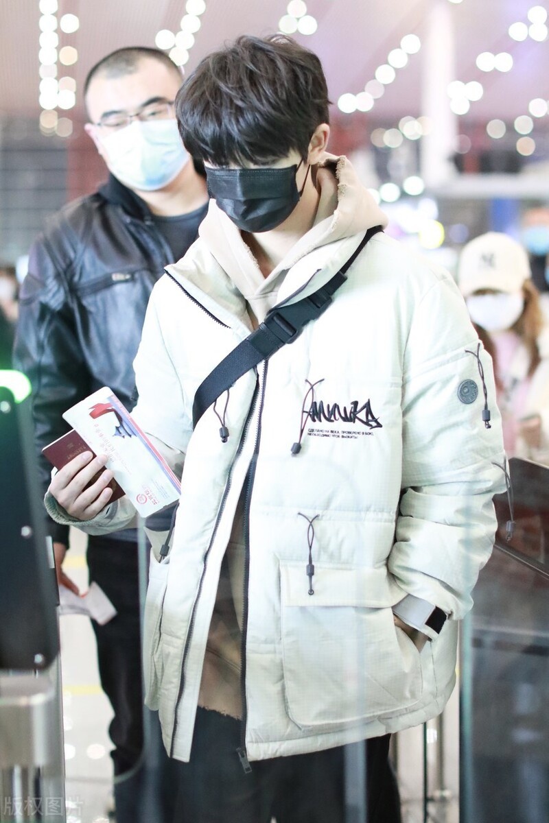 丁程鑫穿白色羽绒服现身机场一路低头略显低调