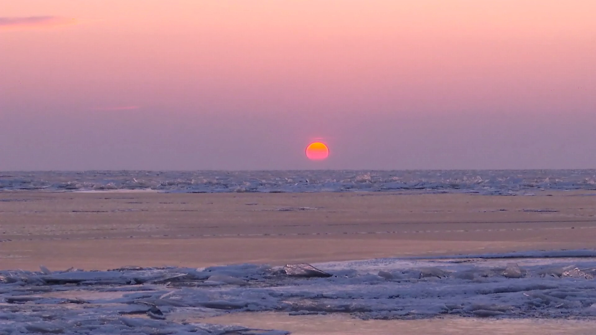 夕阳西下,云层仿佛镶嵌上了金边,落日余晖映红整个兴凯湖湖面.