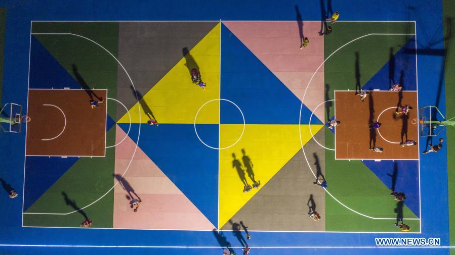 Aerial photo taken on Aug. 26, 2020 shows residents exercising at a basketball court in Beibei District of southwest China's Chongqing. The year 2020 is a juncture where China is wrapping up the plan for the 2016-2020 period and preparing for its next master plan. In 2020, China stepped up efforts to shore up weak links regarding people's livelihoods. A slew of measures has been rolled out to address people's concerns in employment, education, basic medical services, the elderly care, housing, public services, etc. (Photo by Qin Tingfu/Xinhua)