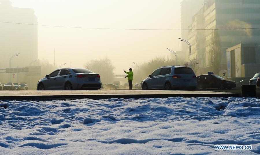 A policeman directs traffic in Urumqi, northwest China's Xinjiang Uygur Autonomous Region, Dec. 16, 2020. The lowest temperature drops to near minus 20 degrees Celsius in Urumqi. (Photo by Hou Zhaokang/Xinhua)