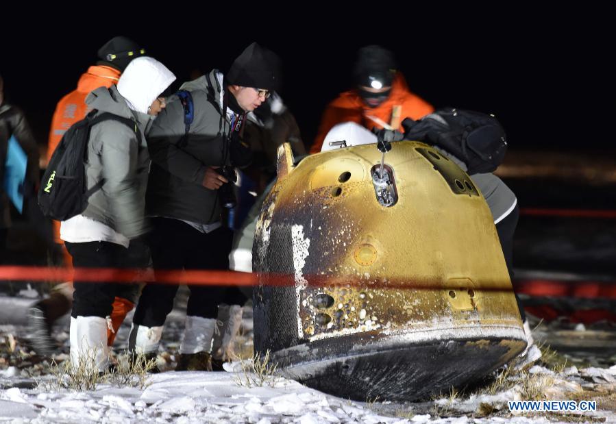 Staff members work at the landing site of the return capsule of China's Chang'e-5 probe in Siziwang Banner, north China's Inner Mongolia Autonomous Region, on Dec. 17, 2020. The return capsule of China's Chang'e-5 probe touched down on Earth in the early hours of Thursday, bringing back the country's first samples collected from the moon, as well as the world's freshest lunar samples in over 40 years. (Xinhua/Ren Junchuan)