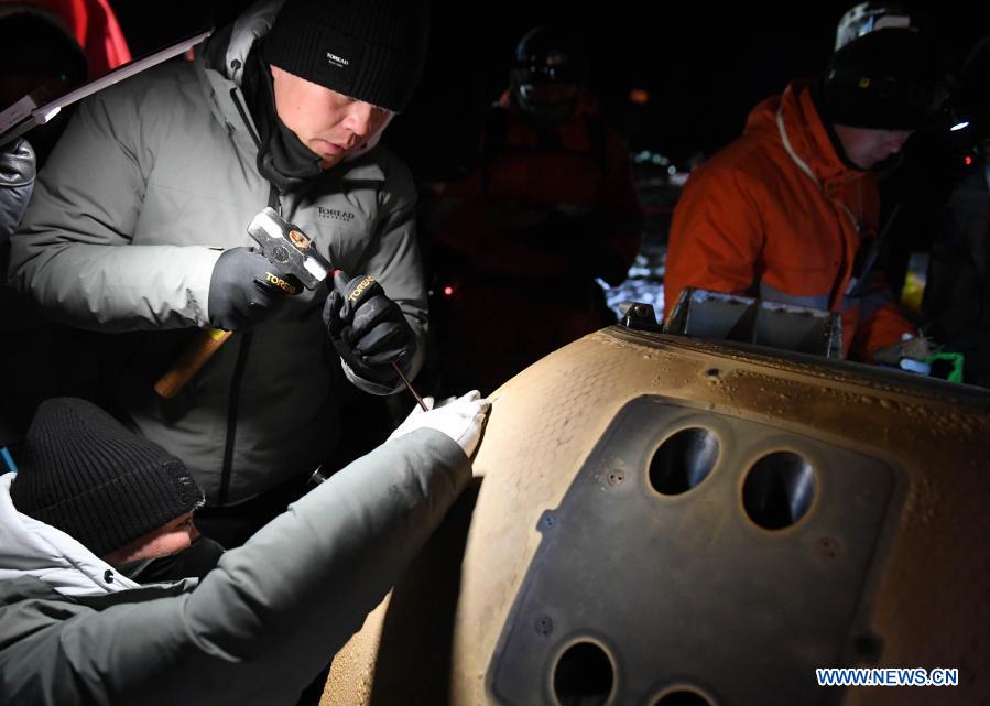 Staff members work at the landing site of the return capsule of China's Chang'e-5 probe in Siziwang Banner, north China's Inner Mongolia Autonomous Region, on Dec. 17, 2020. The return capsule of China's Chang'e-5 probe touched down on Earth in the early hours of Thursday, bringing back the country's first samples collected from the moon, as well as the world's freshest lunar samples in over 40 years. (Xinhua/Lian Zhen)