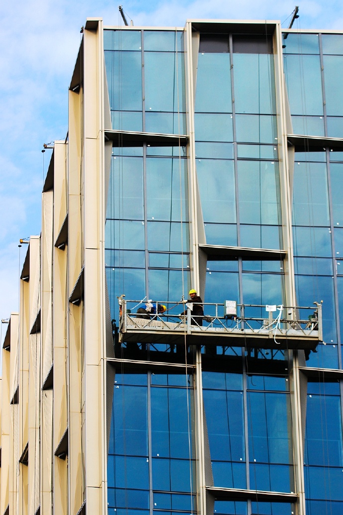 致敬在凛冽刺骨的寒风中站在空中吊篮上作业的幕墙装饰工人