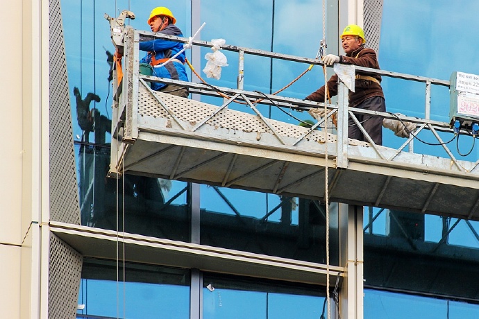 致敬在凛冽刺骨的寒风中站在空中吊篮上作业的幕墙装饰工人