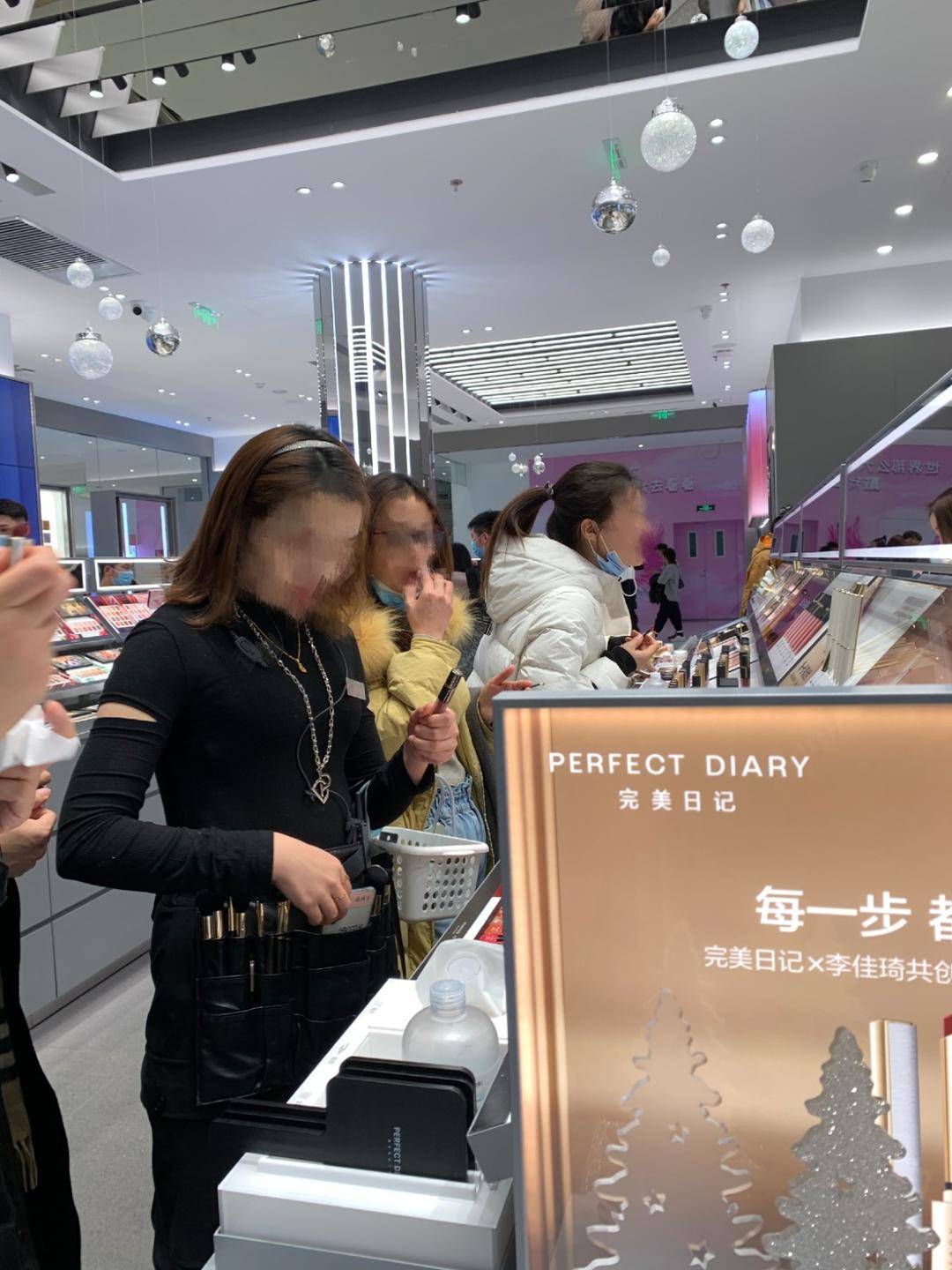 商场美妆店内,服务人员和正在试妆的顾客都没有佩戴或是半摘下口罩.