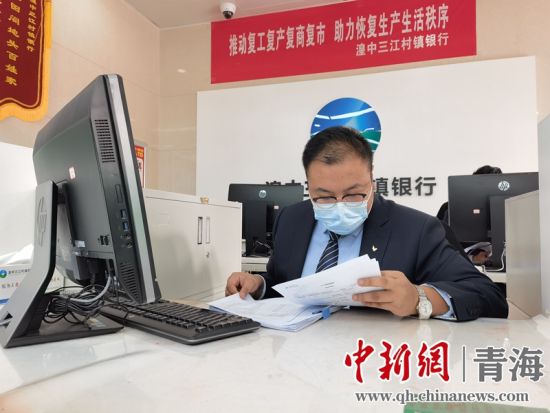 图为湟中三江村镇银行工作人员正在确认客户信息。 祁增蓓摄